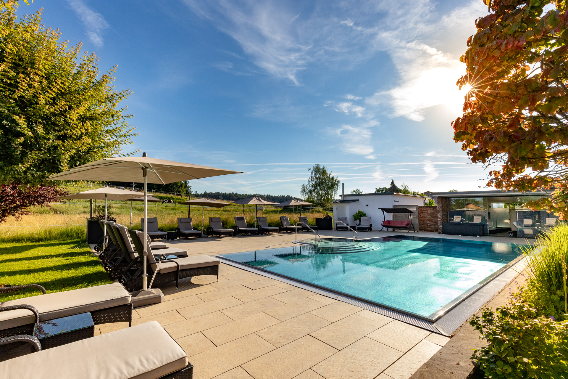 Eleganter Poolbereich mit Liegen und Sonnenschirmen